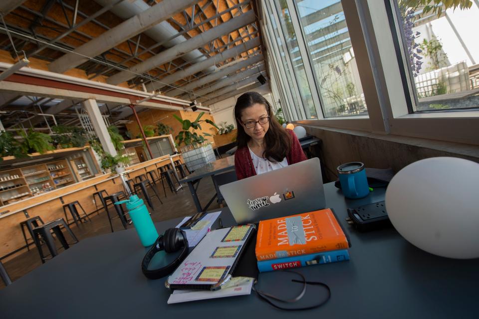 Melia Dicker of Rising Spiral Coaching, counseling for people with ADHD, works in the atrium of Ecoshed, a co-working space in Jackson, Miss., Thursday, April 7, 2022.