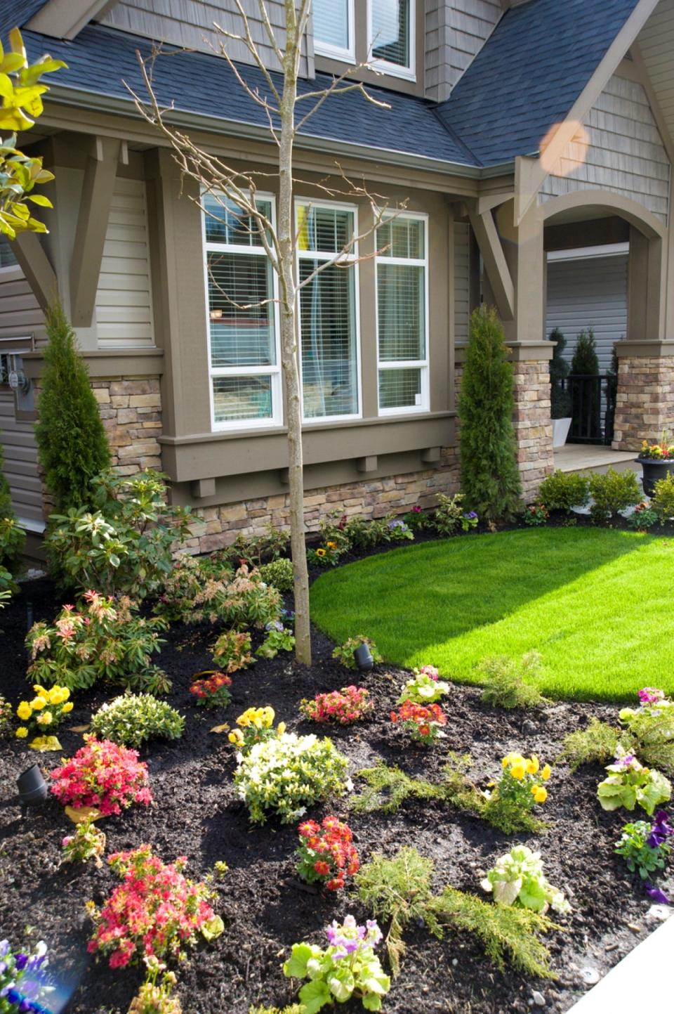 Contemporary house with manicured front garden bed full of flowers and shrubs