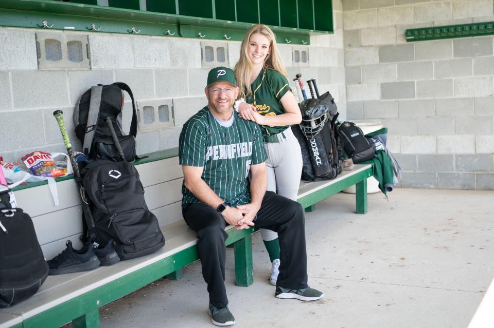 Pennfield varsity baseball coach Rob Moran poses with his daughter Avery Moran, a junior on the Pennfield varsity softball team, in the dugout at Pennfield High School on Wednesday, Apr. 26, 2023.