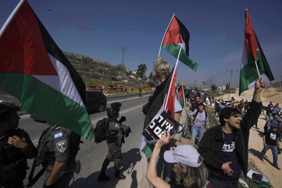 Israeli border police officers block hundreds of Israeli left-wing activists from staging a solidarity rally in the Palestinian town that was set ablaze by radical Jewish settlers earlier this week, next to the West Bank town of Hawara, Friday, March 3, 2023. On Monday scores of Israeli settlers have gone on a violent rampage in the northern West Bank town of Hawara, setting cars and homes on fire after two settlers were killed by a Palestinian gunman. (AP Photo/Majdi Mohammed)