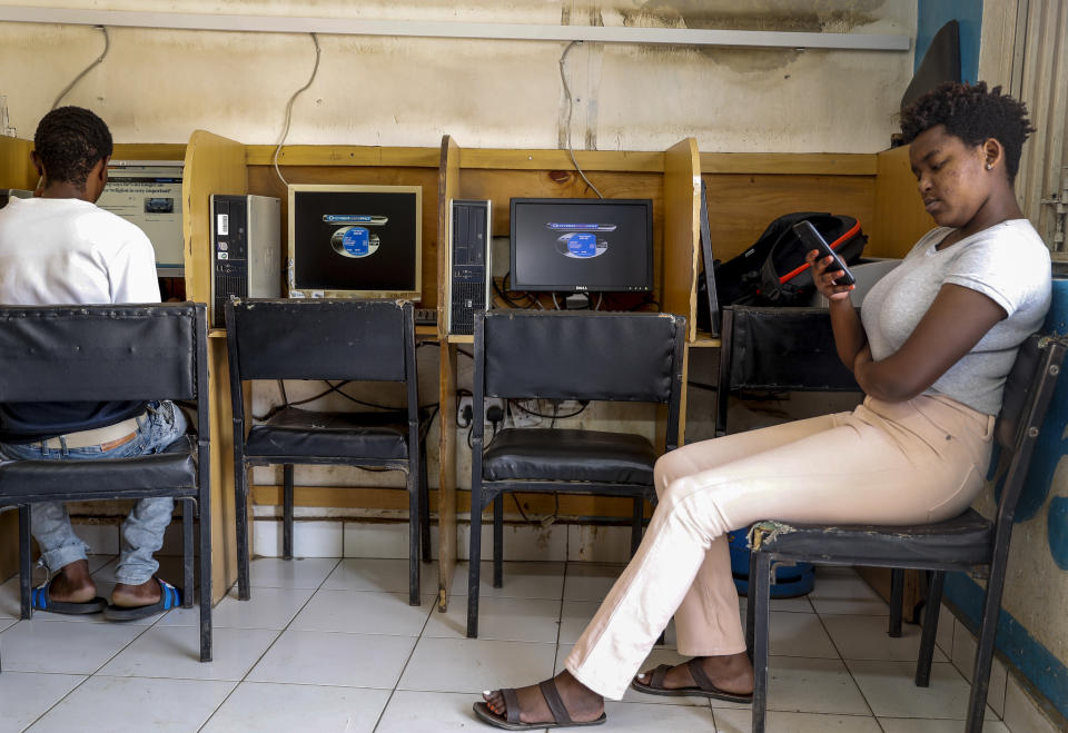 A customer uses the Wi-Fi on her mobile phone at an internet cafe in the low-income Kibera neighborhood of Nairobi, Kenya Wednesday, Sept. 29, 2021. Instead of serving Africa's internet development, millions of internet addresses reserved for Africa have been waylaid, some fraudulently, including in insider machinations linked to a former top employee of the nonprofit that assigns the continent's addresses. (AP Photo/Brian Inganga)