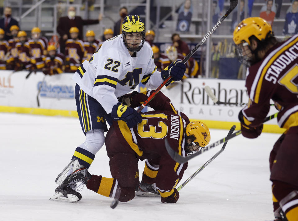 FILE - In this Dec. 8, 2020, file photo, Michigan's Owen Power (22) watches the puck while working against Minnesota's Cullen Munson (13) during an NCAA hockey game in Ann Arbor, Mich. Ann Arbor became a must-stop on the scouting trail because of a buzz-worthy Wolverines lineup featuring a trio of highly touted freshmen in defenseman Owen Power, and forwards Kent Johnson and Mathew Beniers. (AP Photo/Al Goldis, File)