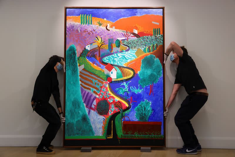 Employees adjust a painting by David Hockney entitled 'Nichols Canyon' which has an estimated value of $35 million at Phillips auction house in London