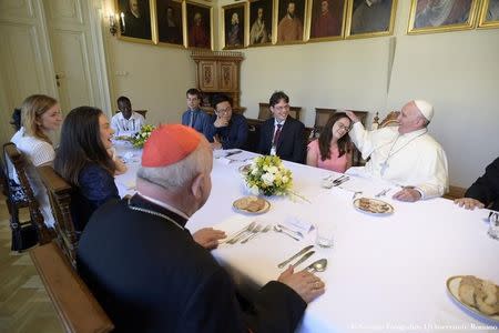 Pope Francis (R) greets a girl during a lunch with youths at the archiepiscopal residence during the World Youth Day in Krakow, Poland July 30, 2016. Osservatore Romano/Handout via Reuters