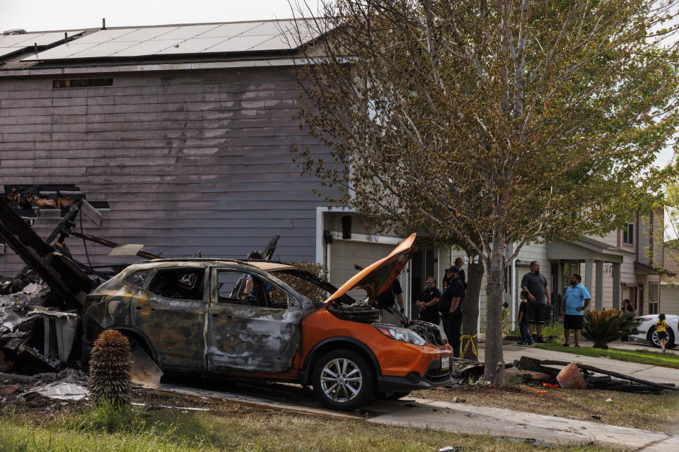 A scorched vehicle is pictured next to rubble at the scene of a house fire where the bodies of four people were discovered, Friday, March 8, 2024, on the far southeast side of San Antonio. (Sam Owens/The San Antonio Express-News via AP)