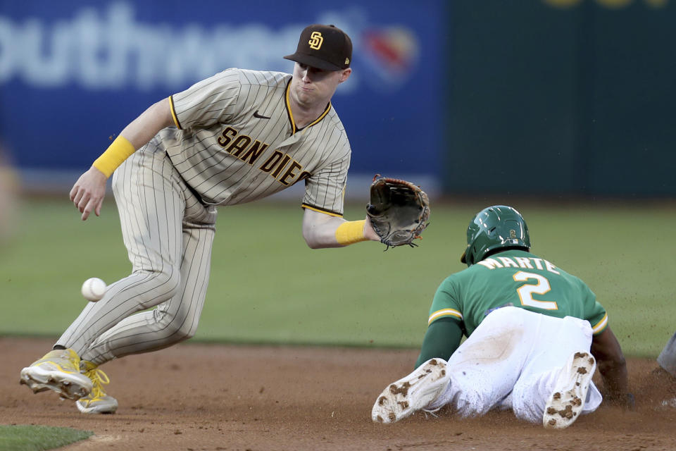 Oakland Athletics' Starling Marte, right, slides safe into second with a stolen base as San Diego Padres' Jake Cronenworth wait for the throw during the third inning of a baseball game in Oakland, Calif., Tuesday, Aug. 3, 2021. (AP Photo/Jed Jacobsohn)