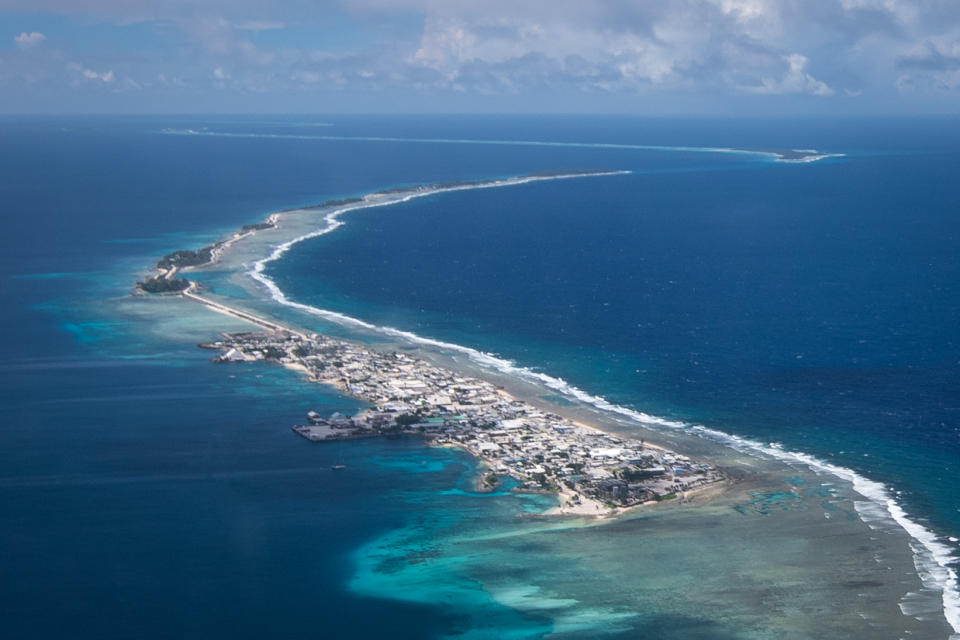 Aerial view of a ring shaped series of islets amidst a blue ocean