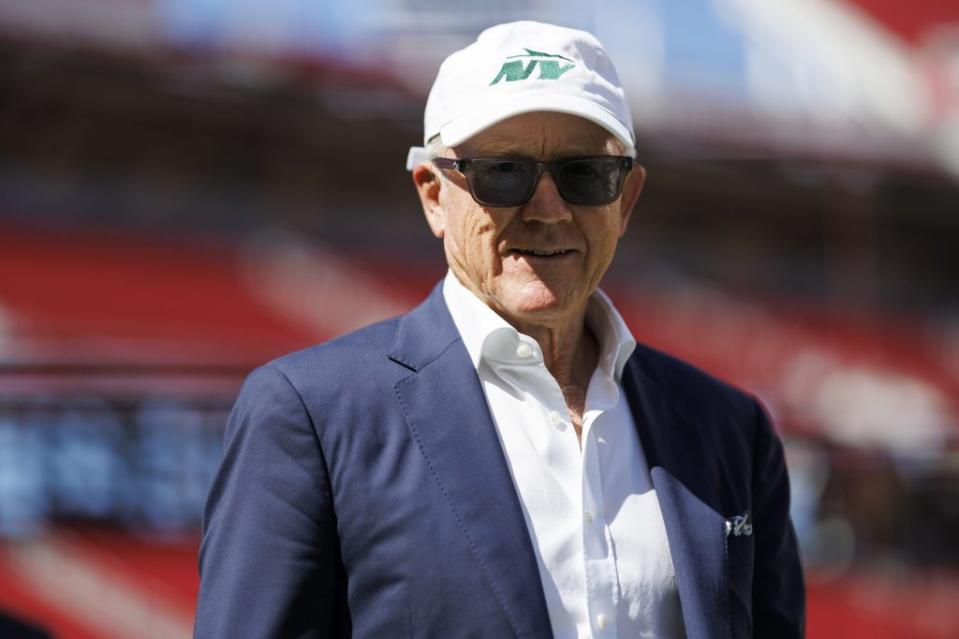 Owner Woody Johnson of the New York Jets walks on the field prior to an NFL football game. He's wearing a hat and sunglasse.