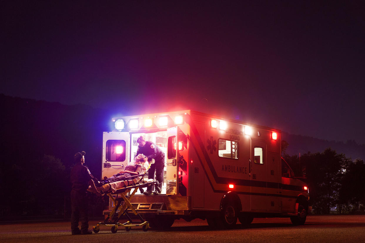 Paramedics carrying patient in ambulance at night Getty Images/Cavan Images