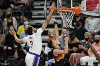Los Angeles Lakers forward Anthony Davis, left, blocks the shot of Phoenix Suns guard Devin Booker, right, during the first half of Game 1 of their NBA basketball first-round playoff series Sunday, May 23, 2021, in Phoenix. (AP Photo/Ross D. Franklin)
