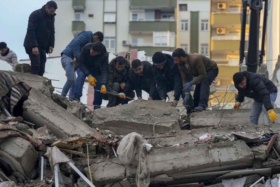 <p>Men remove debris as they search for people in a destroyed building in Adana, Turkey, Monday, Feb. 6, 2023. A powerful quake has knocked down multiple buildings in southeast Turkey and Syria and many casualties are feared. (AP Photo/Khalil Hamra)</p> 