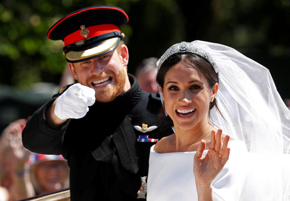 Britain’s Prince Harry gestures next to his wife Meghan as they ride a horse-drawn carriage after their wedding ceremony at St George’s Chapel in Windsor Castle in Windsor, Britain, May 19, 2018. REUTERS/Damir Sagolj     TPX IMAGES OF THE DAY