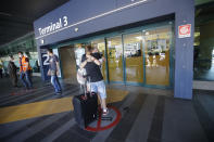 Andrea Monti hugs his girlfriend Katherina Scherf arrived from Dusseldorf, Germany at Rome's Fiumicino airport, Wednesday, June 3, 2020. Rome’s Fiumicino airport sprang back to life on Wednesday as Italy opened regional and international borders in the final phase of easing its long coronavirus lockdown, allowing families and loved ones separated by the global pandemic to finally reunite. (AP Photo/Alessandra Tarantino)