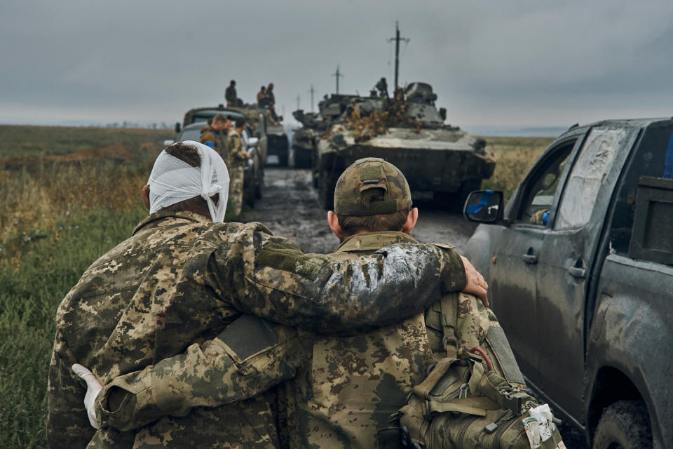 A Ukrainian soldier helps a wounded fellow soldier on the road in the freed territory in the Kharkiv region, Ukraine, Monday, Sept. 12, 2022. Ukrainian troops retook a wide swath of territory from Russia on Monday, pushing all the way back to the northeastern border in some places, and claimed to have captured many Russian soldiers as part of a lightning advance that forced Moscow to make a hasty retreat. (AP Photo/Kostiantyn Liberov)