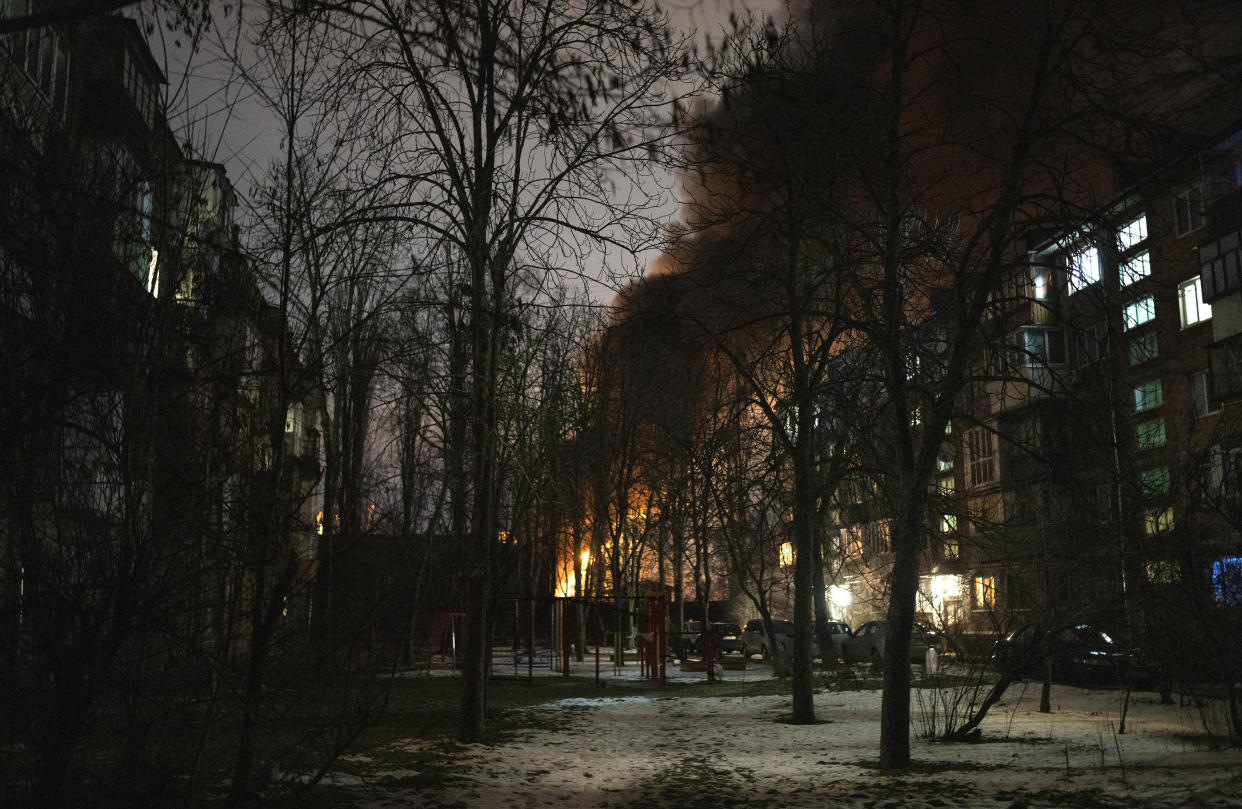 Thick smoke rises between apartment houses from a burning infrastructure project hit during a Russian drone night strike in Kyiv, Ukraine, Monday, Dec. 19, 2022. (AP Photo/Efrem Lukatsky)