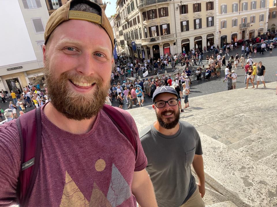 The author and his husband climbing the Spanish Steps in Rome with crowds of people in the background