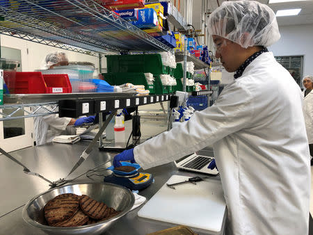 Impossible Foods product development associate scientist Kyle Okada measures plant-based burgers tailor-made for Burger King at a facility in Redwood City, California, U.S. March 26, 2019. Picture taken March 26, 2019. REUTERS/Jane Lanhee Lee