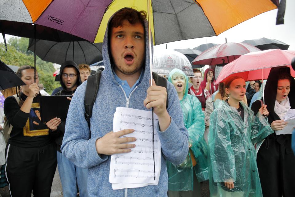 Protesters sing as they gather in front of the Minsk Tractor Works Plant to support workers leaving the plant after their work shift in Minsk, Belarus, Wednesday, Aug. 19, 2020. Belarus President Alexander Lukashenko repeatedly rejected demands to step down and bristled at the idea of talks with the opposition, denouncing the coordination council on Tuesday as a "an attempt to seize power" in the country. Nevertheless, the council is set to convene for the first time Wednesday. (AP Photo/Dmitri Lovetsky)