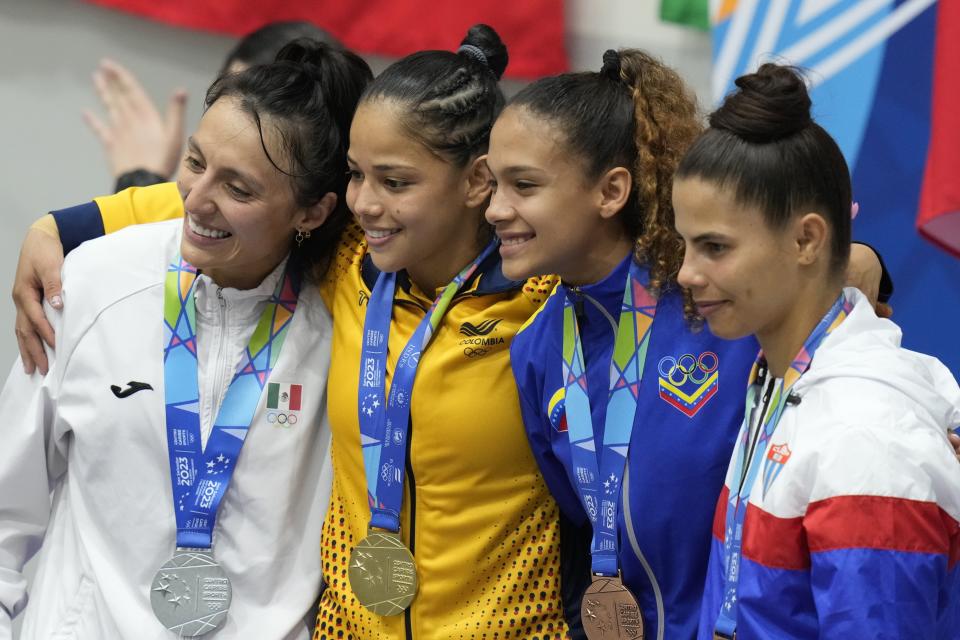 La colombiana Erika Lasso, ganadora del oro en la categoría de 48 kilogramos en el judo, posa con la mexicana Edna Carrillo, que obtuvo la plata, así como con la boricua María Jiménez y la cubana María Giménez, el sábado 24 de junio de 2023, en San Salvador (AP Foto/Arnulfo Franco)