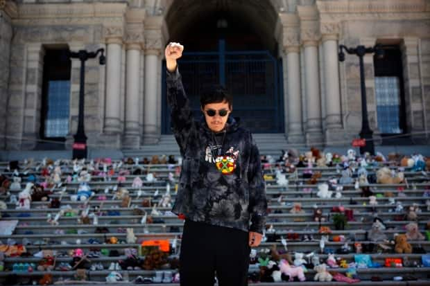 Nipawi Kakinoosit of the Sucker Creek First Nations sings the American Indian Movement song below the steps of the Legislative Assembly of British Columbia in Victoria on June 8, following a ceremony for what is reported to be unmarked burial sites of children's remains adjacent to a former residential school in Kamloops, B.C. (The Canadian Press/Chad Hipolito - image credit)