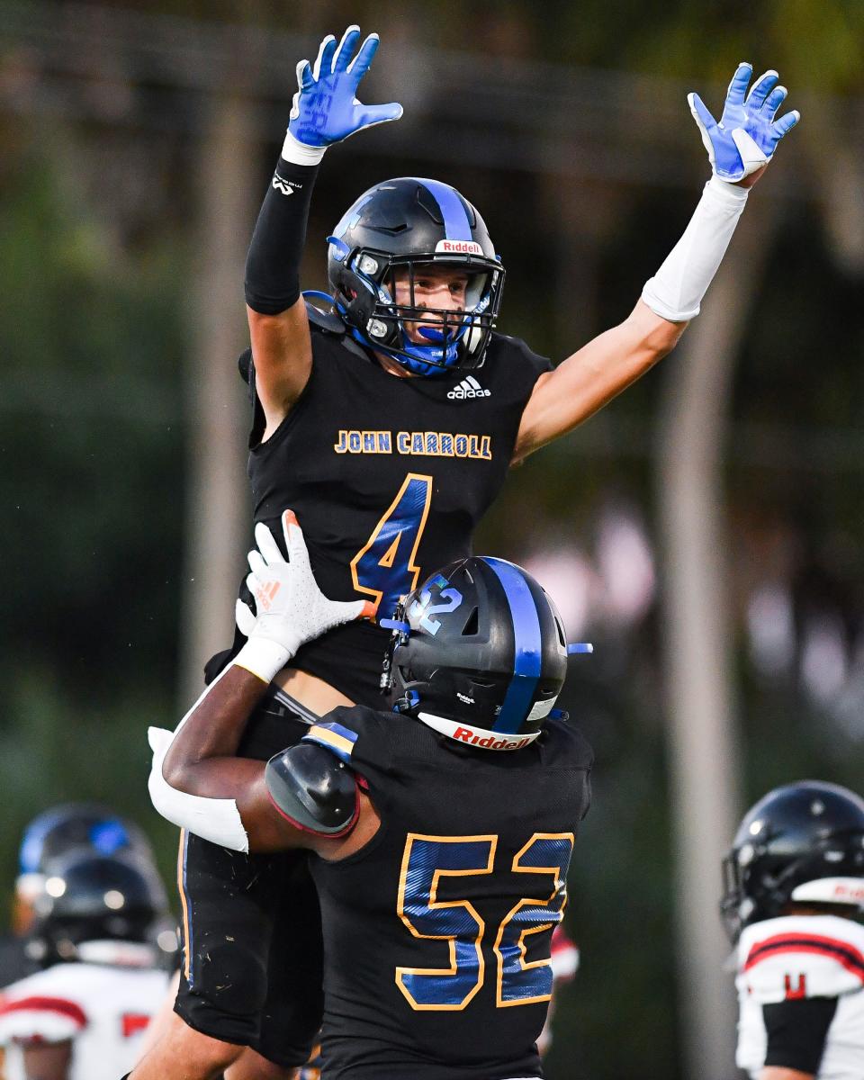 John Carroll Catholic's Connor Zrallack (4) celebrates a touchdown with teammate Wilky Denaud (52) against South Fork during the first quarter in a high school football game on Thursday, Sept. 30, 2021, at John Carroll Catholic High School in Fort Pierce. John Carroll Catholic won 20-0.