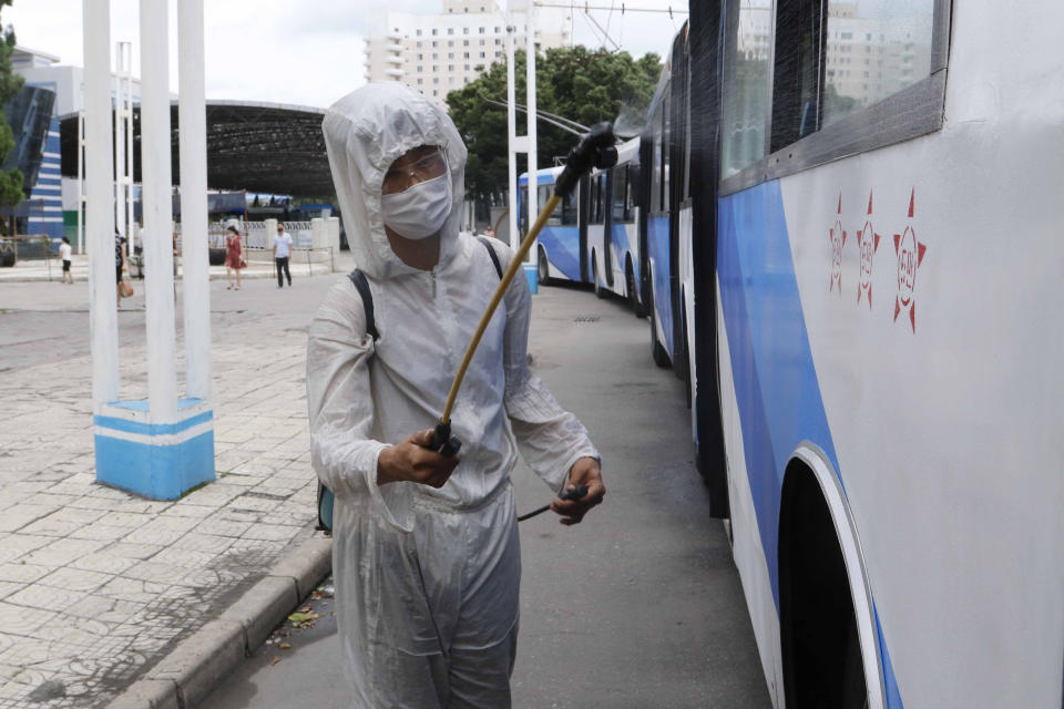 A man in a protective suit disinfects a trolley bus to help curb the spread of the coronavirus in Pyongyang, North Korea, Thursday, Aug. 13, 2020. (AP Photo/Cha Song Ho)