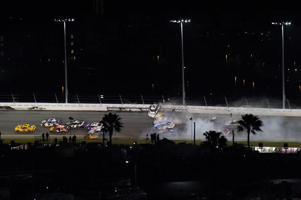 Racers crash during the last lap in the NASCAR Daytona 500 auto race at Daytona International Speedway, Monday, Feb. 15, 2021, in Daytona Beach, Fla. Michael McDowell, left, went on to win the race. Michael McDowell, left, went on to win the race. Among the other drivers are Joey Logano (22), Brad Keselowski (2) and Kyle Busch (18). (AP Photo/Chris O'Meara)