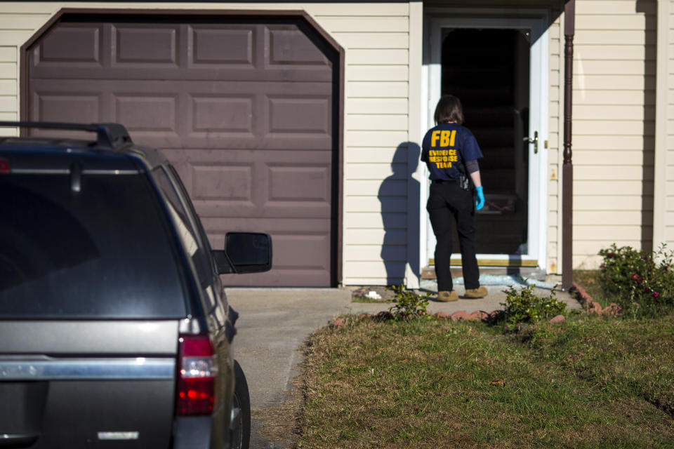 An FBI agent enters the home of Andre Bing, Wednesday, Nov. 23, 2022, in Chesapeake, Va. Bing, a Walmart manager, opened fire on fellow employees in the break room of a Virginia store, killing six people in the country’s second high-profile mass shooting in four days, police and witnesses said Wednesday. (AP Photo/John C. Clark)