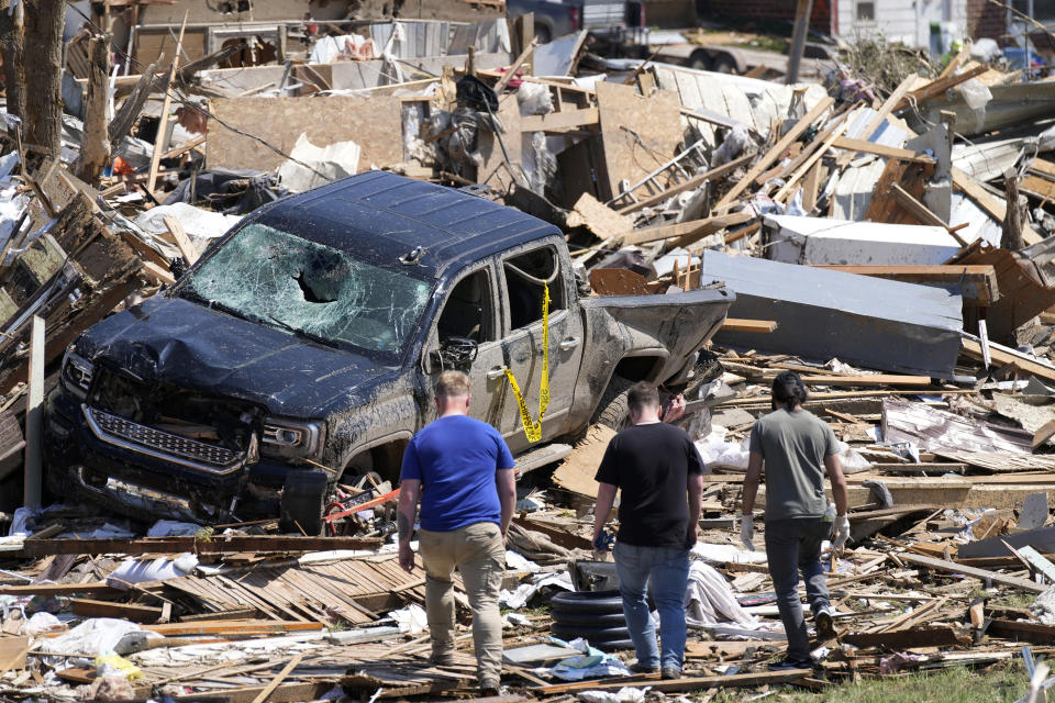 FILE - Local residents walk among the debris from tornado damaged homes, May 22, 2024, in Greenfield, Iowa. Record flooding and powerful tornadoes ravaged parts of Iowa for weeks this spring, destroying or damaging thousands of homes, closing roads and bridges and costing over $130 million in infrastructure damage, officials said Thursday, July 11. (AP Photo/Charlie Neibergall, File)