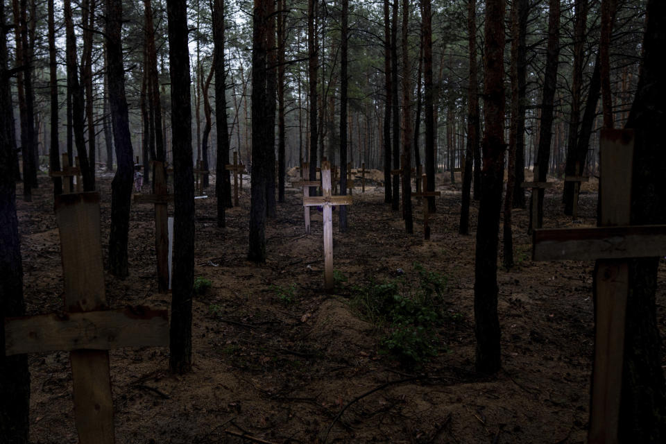 Unidentified graves of civilians and Ukrainian soldiers are marked with a cross in a cemetery in the recently liberated town of Izium, Ukraine, Thursday, Sept. 15, 2022. At the mass grave site created by the Russians and discovered in the woods of Izium, at least 30 of the 447 bodies recently excavated bore visible marks of torture – bound hands, close gunshot wounds, knife wounds and broken limbs, according to the Kharkiv regional prosecutor's office. (AP Photo/Evgeniy Maloletka)