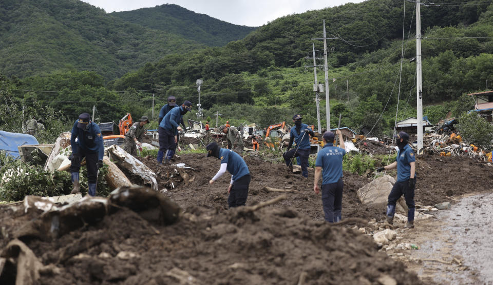 Rescue workers search for people at houses collapsed after a landslide caused by heavy rain in Yecheon, South Korea, Monday, July 17, 2023. Heavy downpours lashed South Korea for a ninth day on Monday as rescue workers struggled to search for survivors in landslides, buckled homes and swamped vehicles in the most destructive storm to hit the country this year. (Kim Dong-min/Yonhap via AP)