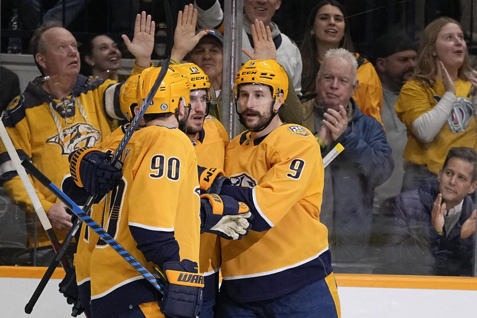 Nashville Predators teammates congratulate left wing Filip Forsberg (9) after a goal against the Tampa Bay Lightning during the second period of an NHL hockey game Thursday, Dec. 7, 2023 in Nashville, Tenn. (AP Photo/George Walker IV)