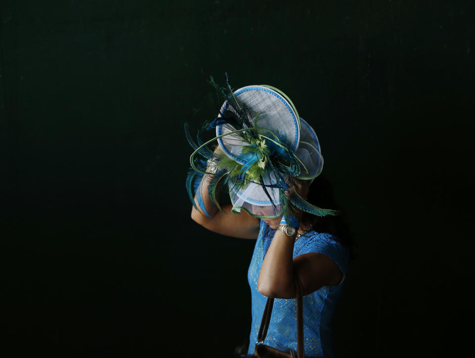 A woman makes her way to the track before the 140th running of the Kentucky Derby horse race at Churchill Downs Saturday, May 3, 2014, in Louisville, Ky. (AP Photo/Matt Slocum)