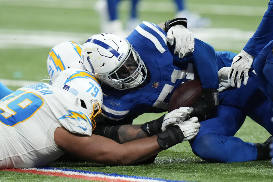 Indianapolis Colts' Kwity Paye (51) recovers a fumble by Los Angeles Chargers quarterback Justin Herbert during the second half of an NFL football game, Monday, Dec. 26, 2022, in Indianapolis. (AP Photo/AJ Mast)