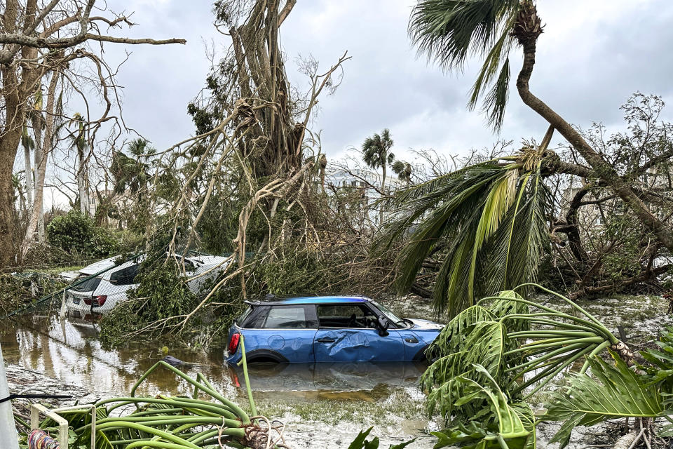 Image: Damaged vehicles and debris are seen on Sanibel Island, Fla., during Hurricane Ian. (Chuck Larsen / SantivaChronicle.com via AP)