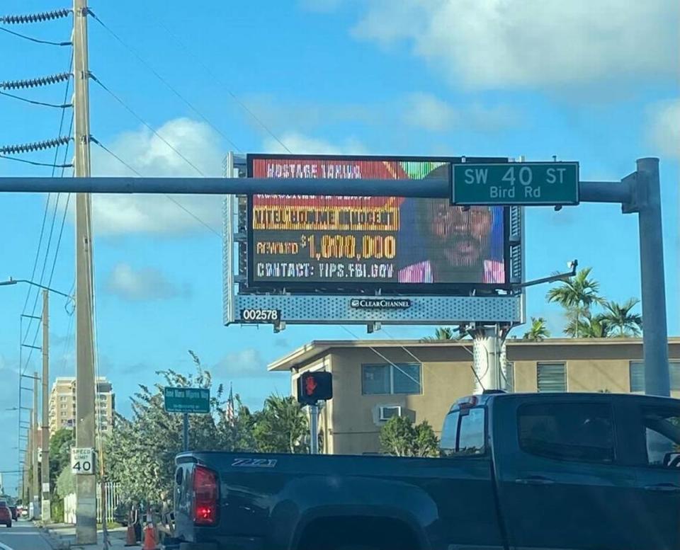 A billboard displayed on Bird Road Friday, Oct. 27, 2023, seeks information on the whereabouts of Haitian gang leader Vitel’homme Innocent.