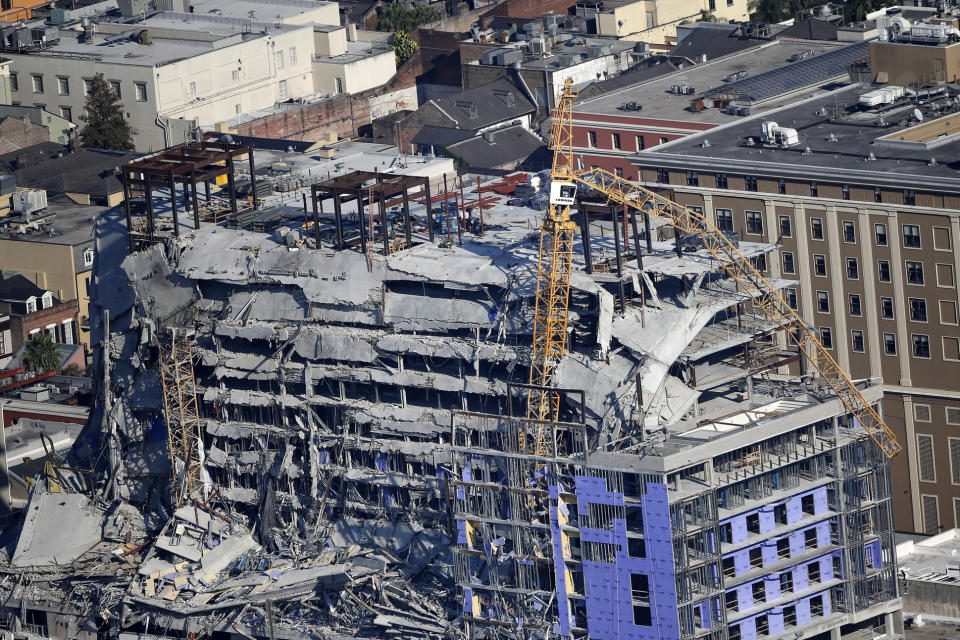 Two large cranes from the Hard Rock Hotel construction collapse are seen in this aerial photo after crashing down, after being detonated for implosion in New Orleans, Sunday, Oct. 20, 2019. (AP Photo/Gerald Herbert)