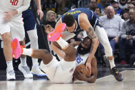 Los Angeles Clippers guard James Harden, below, and Denver Nuggets forward Michael Porter Jr. grapple for a loose ball during the first half of an NBA basketball game Thursday, April 4, 2024, in Los Angeles. (AP Photo/Mark J. Terrill)