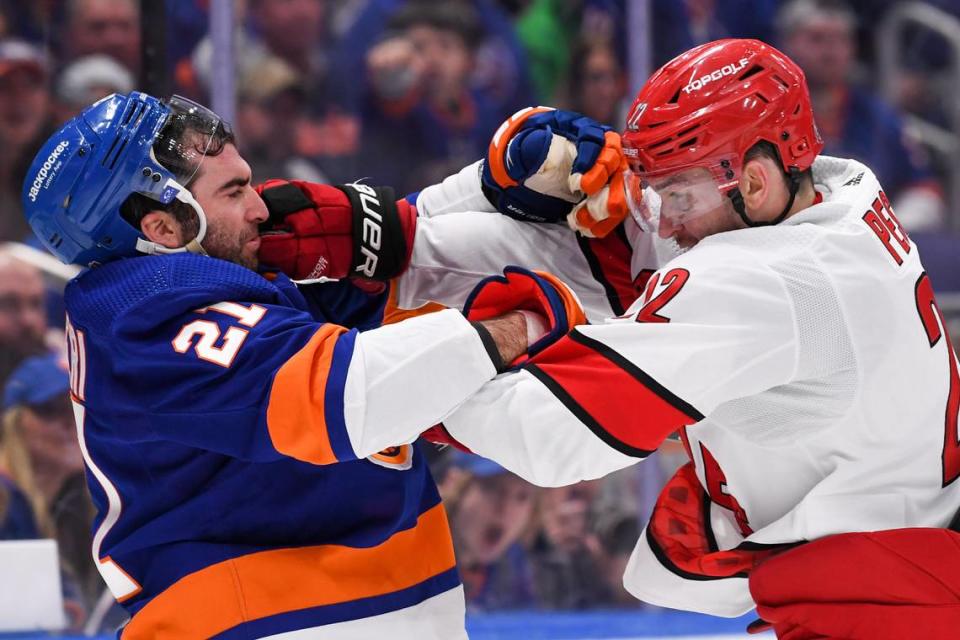 New York Islanders center Kyle Palmieri (21) and Carolina Hurricanes defenseman Brett Pesce (22) fight during the second period in game three of the first round of the 2023 Stanley Cup Playoffs at UBS Arena.