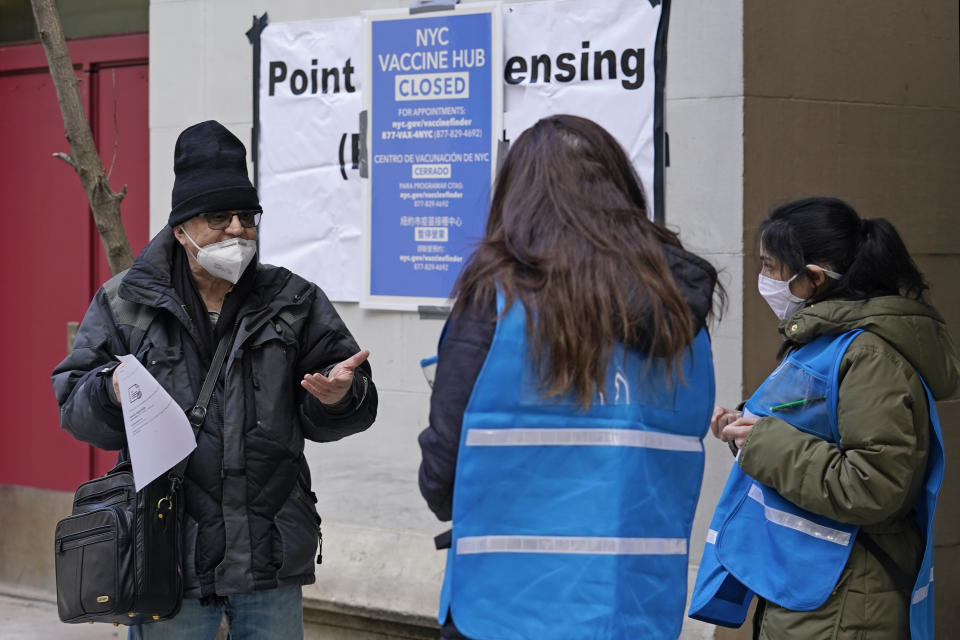 FILE - In this Jan. 21, 2021, file photo, a man who came to get a COVID-19 vaccine holds his paperwork as he talks to a New York City health department worker outside a closed vaccine hub in the Brooklyn borough of New York. An increasing number of COVID-19 vaccination sites around the U.S. are canceling appointments because of vaccine shortages in a rollout so rife with confusion and unexplained bottlenecks. (AP Photo/Kathy Willens, File)