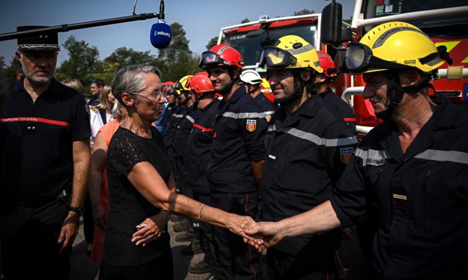 France’s prime minister, Élisabeth Borne (centre), greets firefighters 