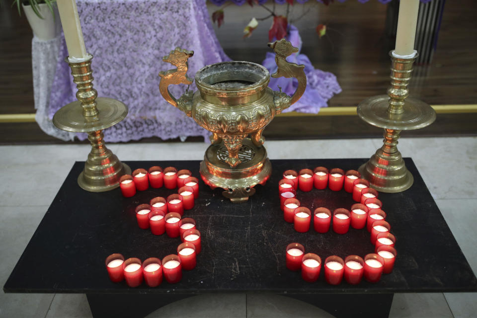 Candles are laid out as priest of the Vietnamese Catholic Cathedral in east London, Father Simon Thang Duc Nguyen speaks at The Holy Name and Our Lady of the Sacred Heart Church, London's Vietnamese church, in east London. Saturday Nov. 2, 2019, during a service and vigil to honor the 39 victims who died in a refrigerated truck container found on Oct. 23. The community is mourning the unidentified victims, who were trying to enter Britain in hopes of finding opportunity. (Yui Mok/PA via AP)