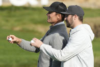 Former NFL quarterback Tom Brady, left, gestures next to Buffalo Bills quarterback Josh Allen on the 17th green at Pebble Beach Golf Links during the second round of the AT&T Pebble Beach National Pro-Am golf tournament in Pebble Beach, Calif., Friday, Feb. 2, 2024. (AP Photo/Eric Risberg)