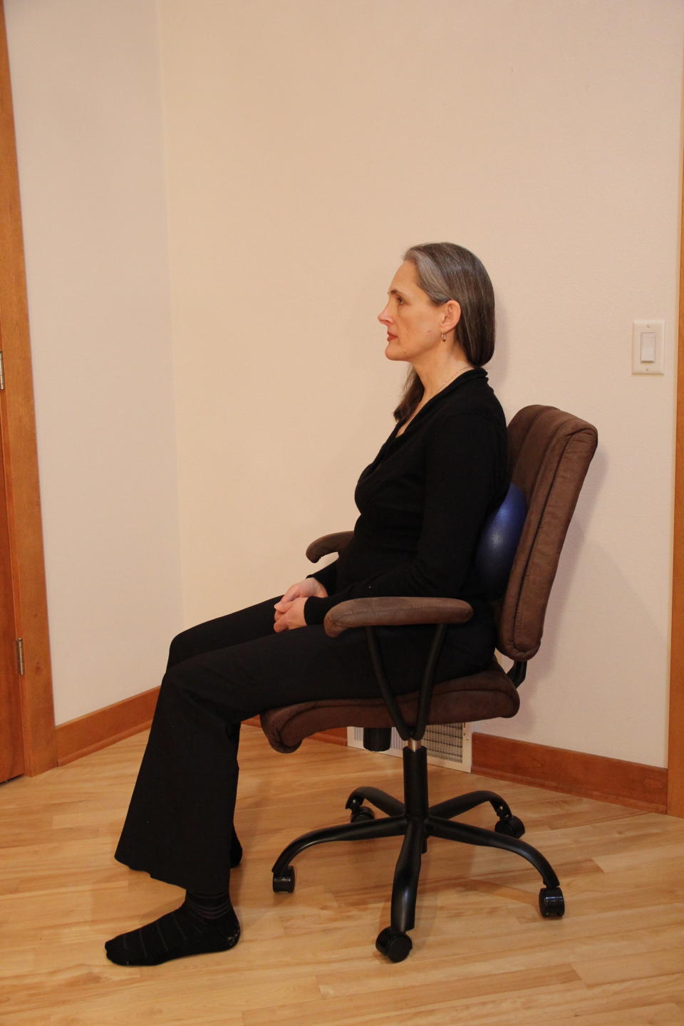 Bryan demonstrates how employees can use a fitness ball to retrofit an oversized office chair. (Photo: The Body at Work Ergonomics/Sara Kraft)