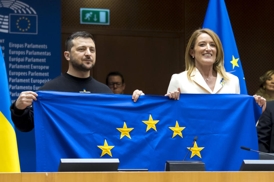 In this photo provided by the European Parliament, Ukraine's President Volodymyr Zelenskyy, left, and European Parliament President Roberta Metsola hold up a European Union flag during a plenary session at the European Parliment in Brussels, Thursday, Feb. 9, 2023. Zelenskyy says that “a Ukraine that is winning” should become a European Union member. Zelenskky made his comments during an address on Thursday to the European Parliament on a rare trip outside Ukraine which has been trying to repel a full-scale invasion by Russia for nearly a year. (Daina Le Lardice, European Parliament via AP)