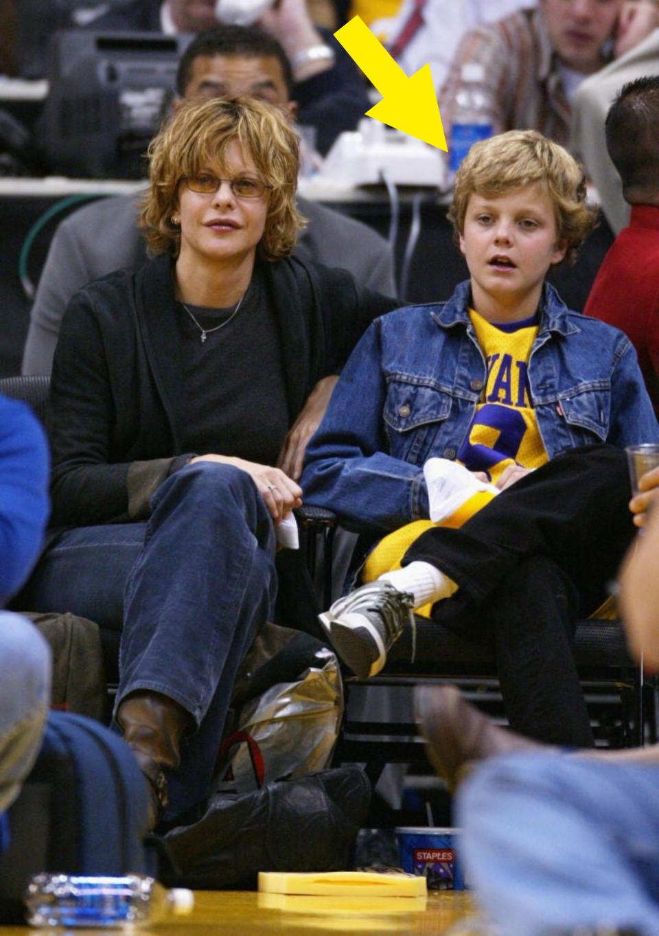 him sitting next to his mom at a sports event