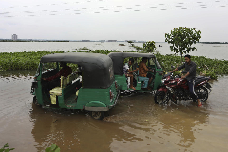 Auto rickshaws drive through a flooded road in Bagha area in Sylhet, Bangladesh, Monday, May 23, 2022. Pre-monsoon deluges have flooded parts of India and Bangladesh, killing at least 24 people in recent weeks and sending 90,000 people into shelters, authorities said Monday. (AP Photo)