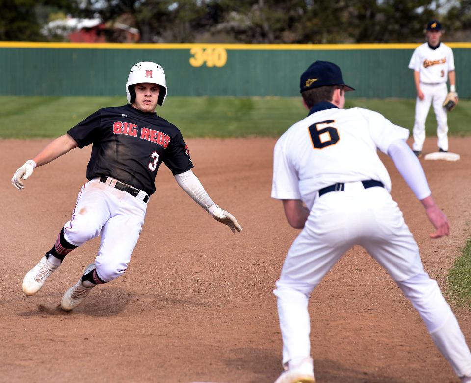 Jett Isaacs of Milan slides safely into third base with Airport third baseman Cole McBeath waiting for the throw last year.