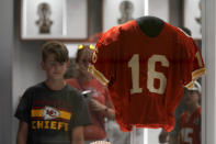 A fan looks at the jersey of former Kansas City Chiefs quarterback Len Dawson before the start of an NFL preseason football game between the Kansas City Chiefs and the Green Bay Packers Thursday, Aug. 25, 2022, in Kansas City, Mo. Dawson, who helped the Kansas City Chiefs to their first Super Bowl title and is in the Pro Football Hall of Fame as a player and broadcaster, died Wednesday at the age of 87. (AP Photo/Charlie Riedel)
