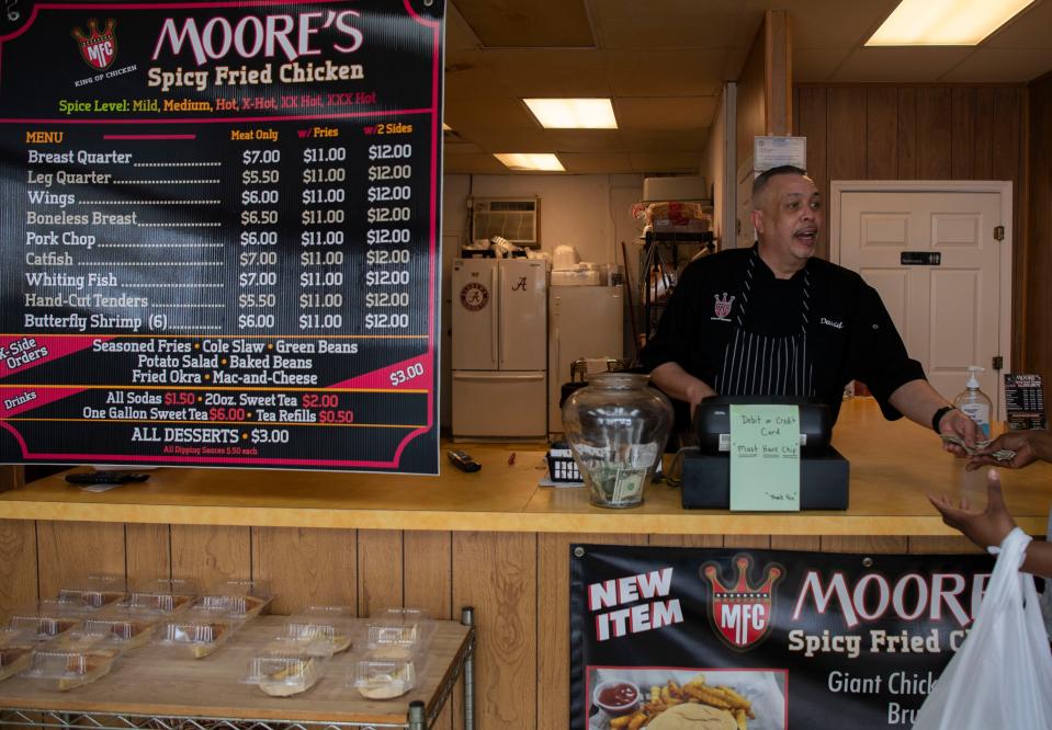 David Moore owner of Moore's Spicy Fried Chicken assists a customer at his restaurant in Hendersonville, Tenn., Thursday, March 7, 2024.